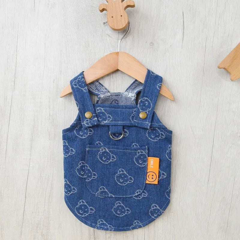 Small white dog wearing a light blue denim princess dress with a frilled skirt.
