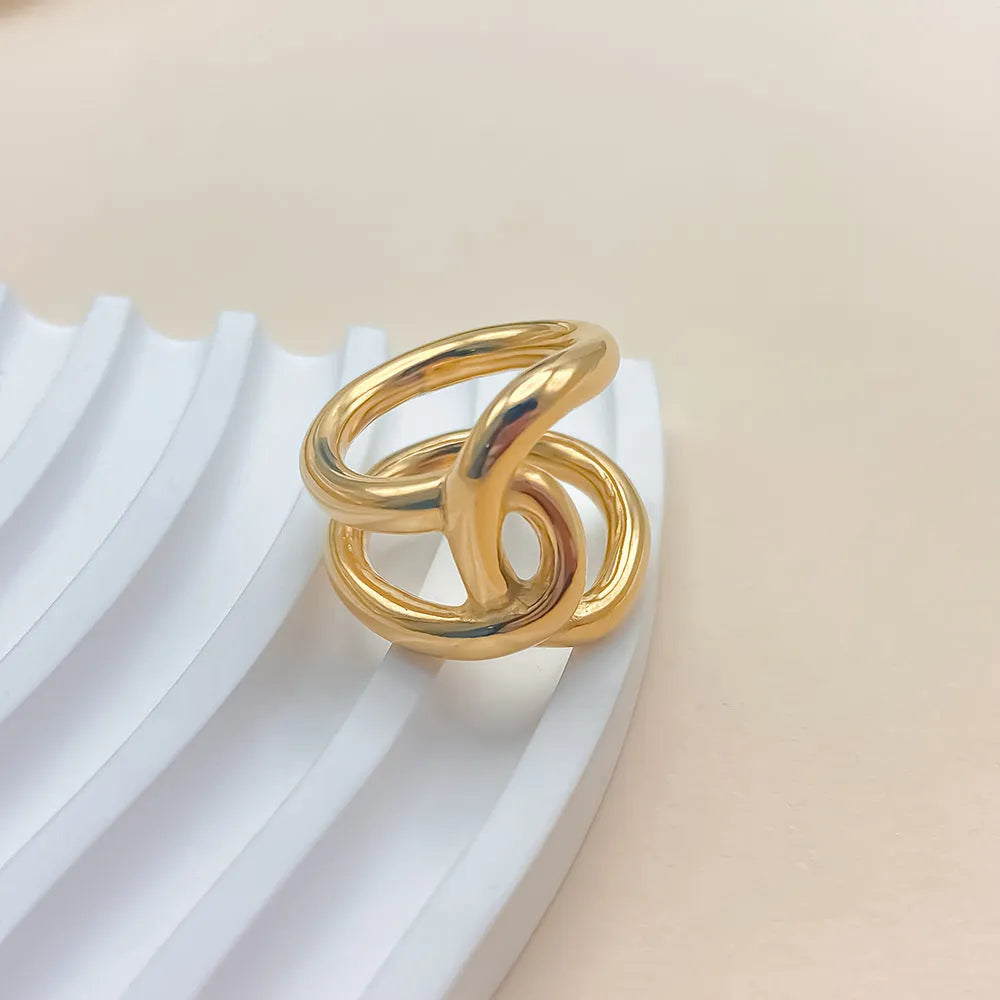 Women's stainless steel adjustable knotted ring in gold or steel colour on a U-shape geometric band.