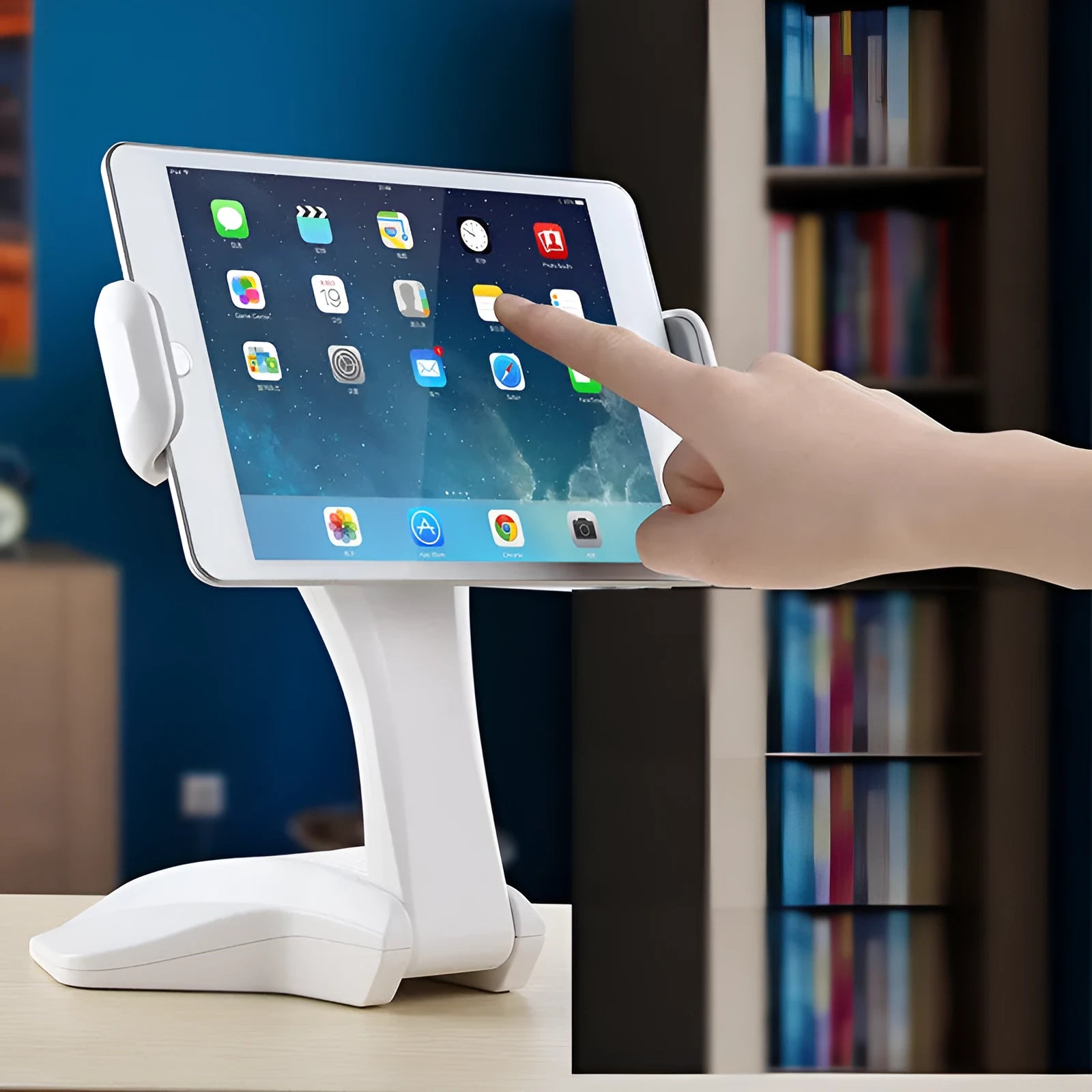 White adjustable tablet stand with a wide clip, holding a tablet on a table.