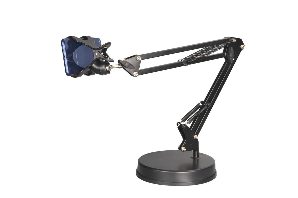 Black universal phone stand with long rotating metal arms and a heavy round base on a wooden desk.