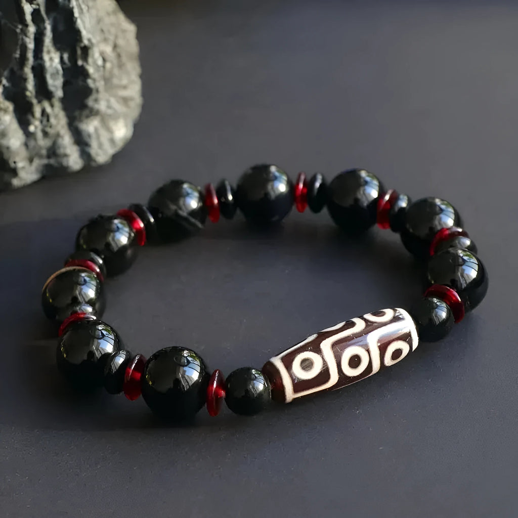 Black agate dzi bead bracelet with geometric 11mm beads on a hand-woven cord.