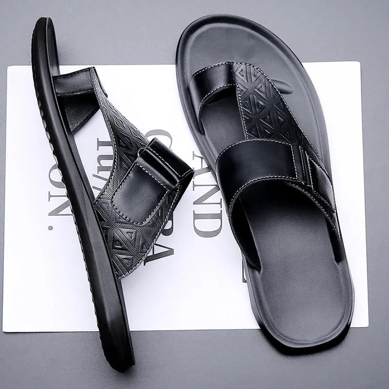 Men's white cowhide open-toe beach slippers with a rubber sole on a sandy background.