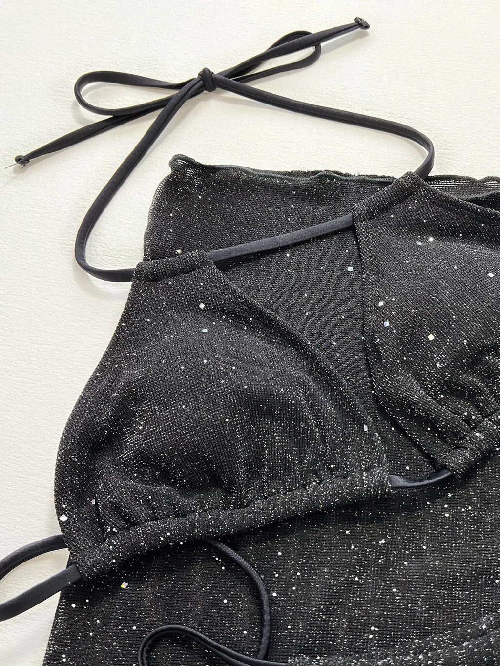Black three piece bikini swimsuit set with a top and shorts on a mannequin.