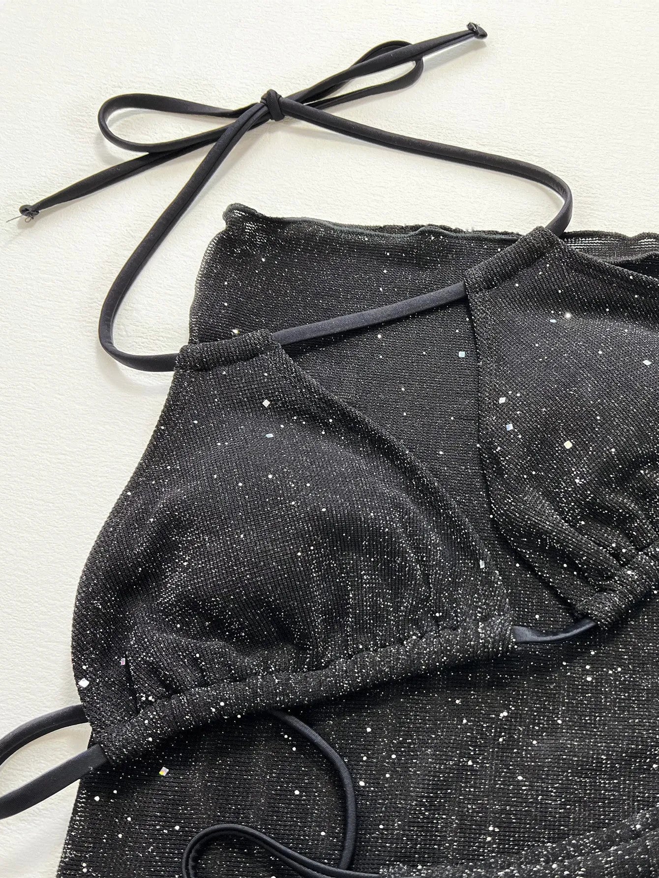 Black three piece bikini swimsuit set with a top and shorts on a mannequin.