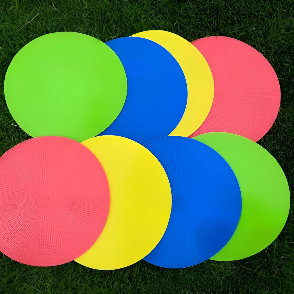 Soft TPE football training marker pad in assorted colours on grass, 23cm diameter.