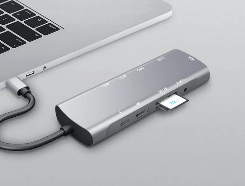 Grey aluminium USB-C docking station showing HDMI, VGA, USB, PD charging, and SD card ports.