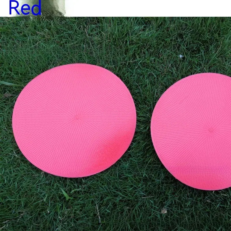 Soft TPE football training marker pad in assorted colours on grass, 23cm diameter.