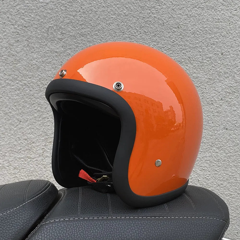 Retro-style open face motorcycle helmet in fibreglass, shown in a selection of colours including cement grey and matte black.