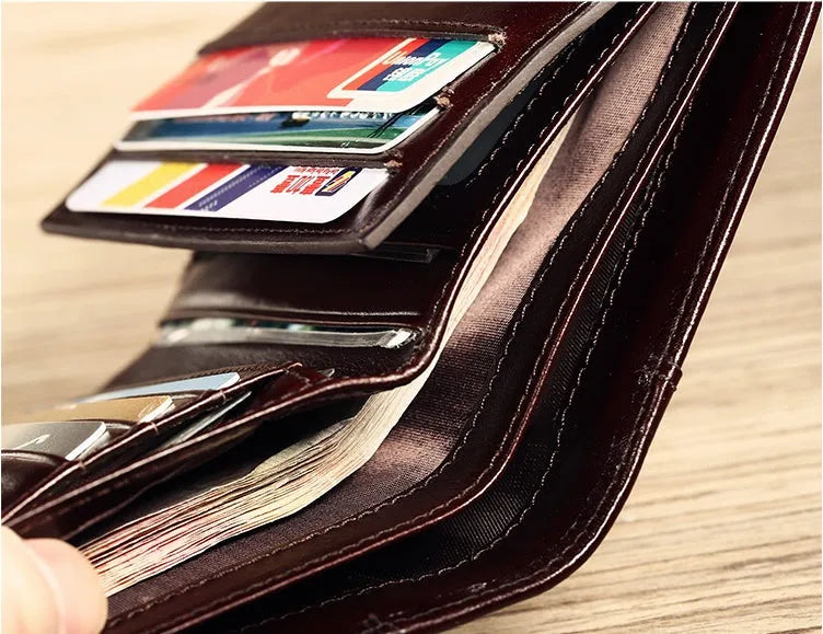 Men's black leather bifold wallet open to show card slots, coin pocket, and photo window.