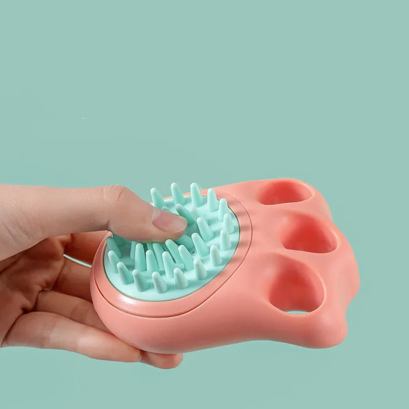 Multi-colour plastic pet bath brush with bristles on one side and a cat claw comb design on the reverse.