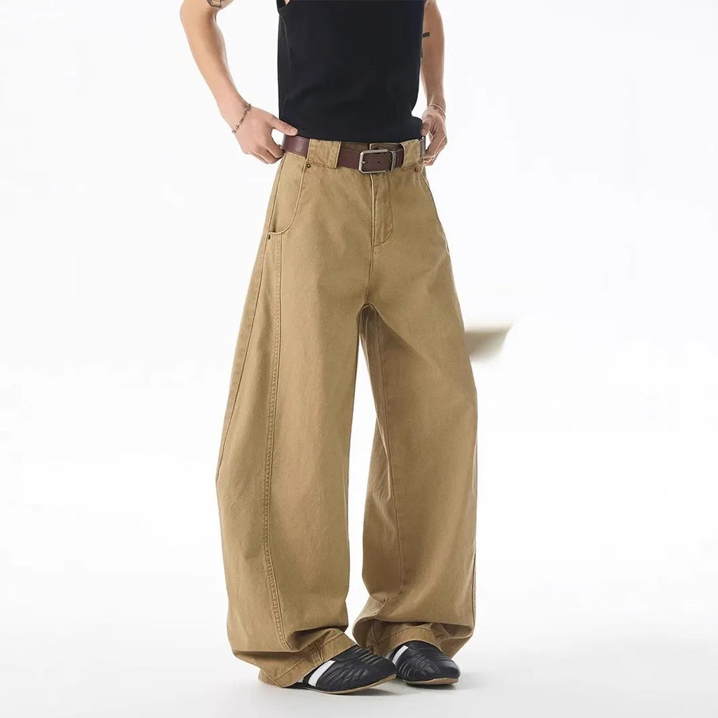 Brown loose fit straight leg men's jeans on a neutral background, showing button fly detail.
