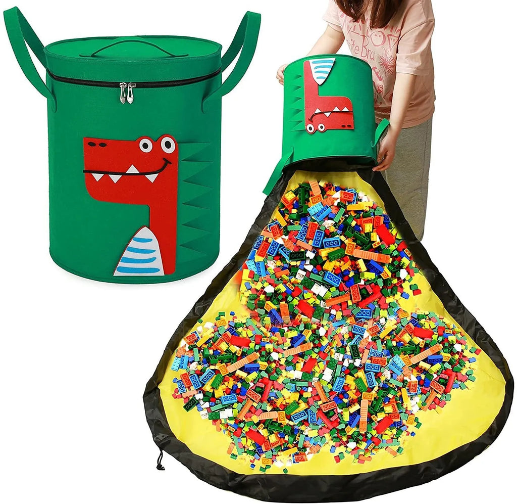 Green felt cube-shaped toy storage bag opened flat as a play mat next to toys, showing pull rope.