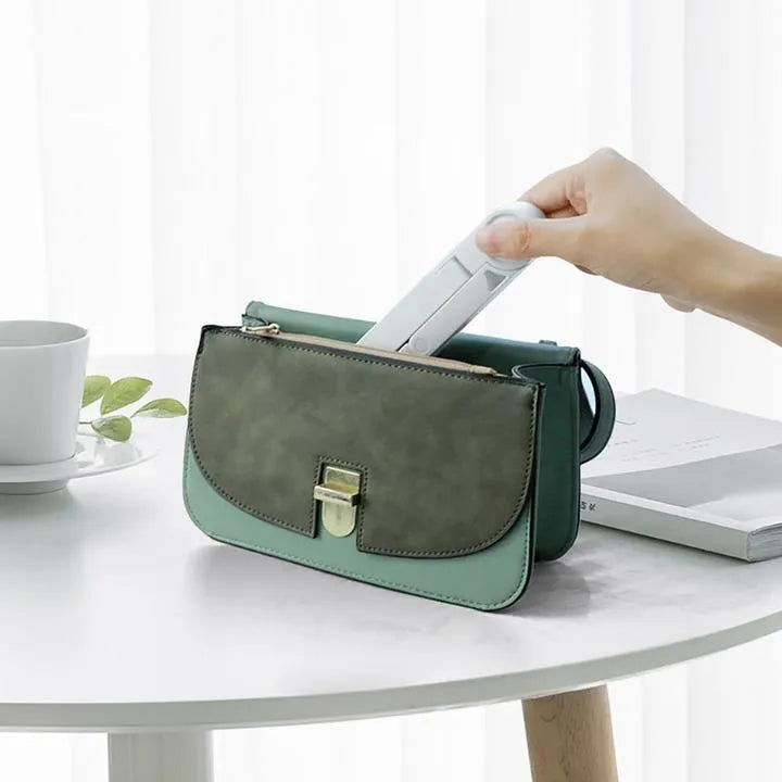 Black foldable tablet holder displaying adjustable angles with phone in landscape mode on non-slip surface