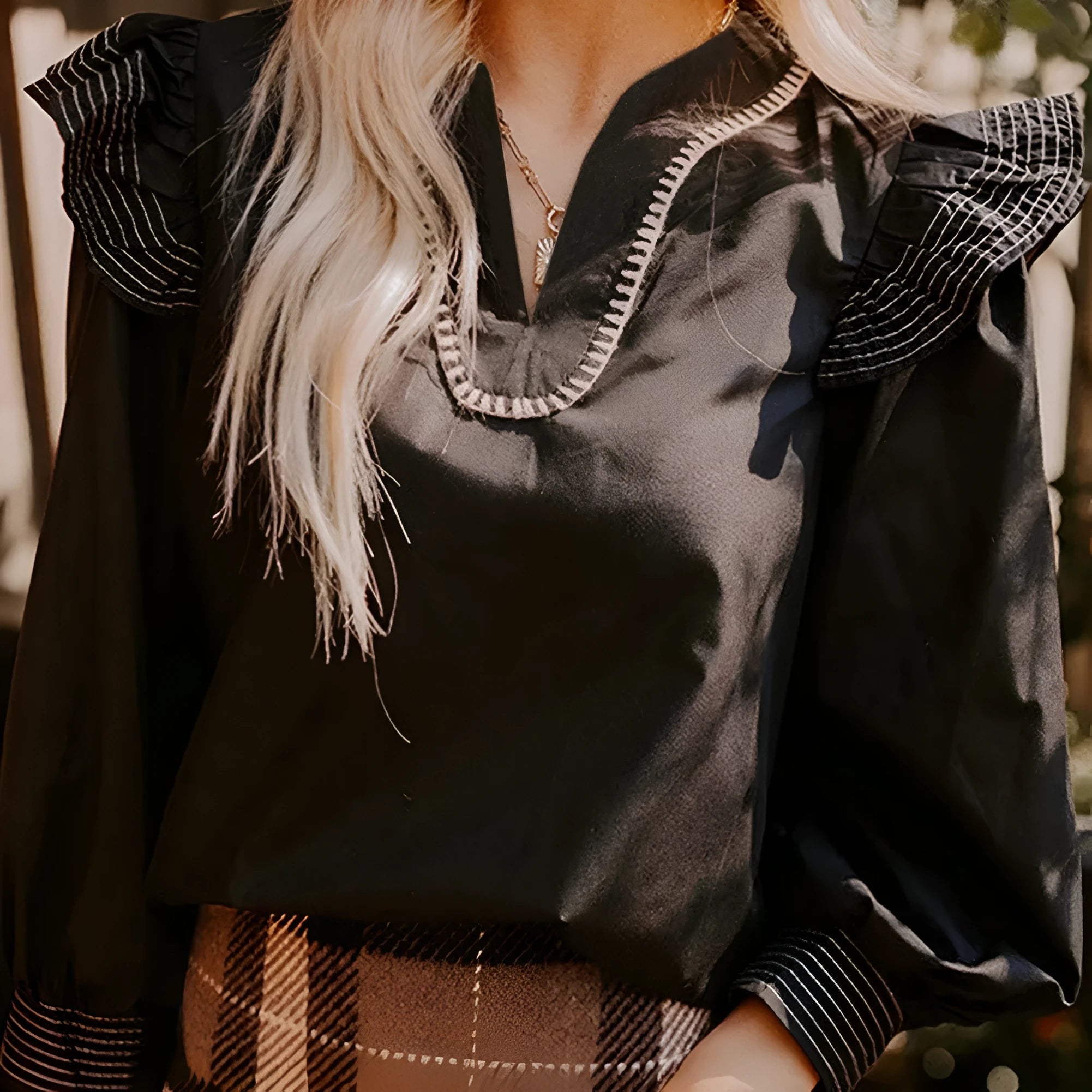 Black long sleeve V-neck blouse with ruffle detail and contrast stitching
