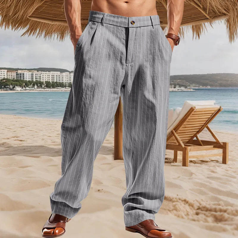 Man wearing beige striped linen trousers with a high waist and wide loose legs.