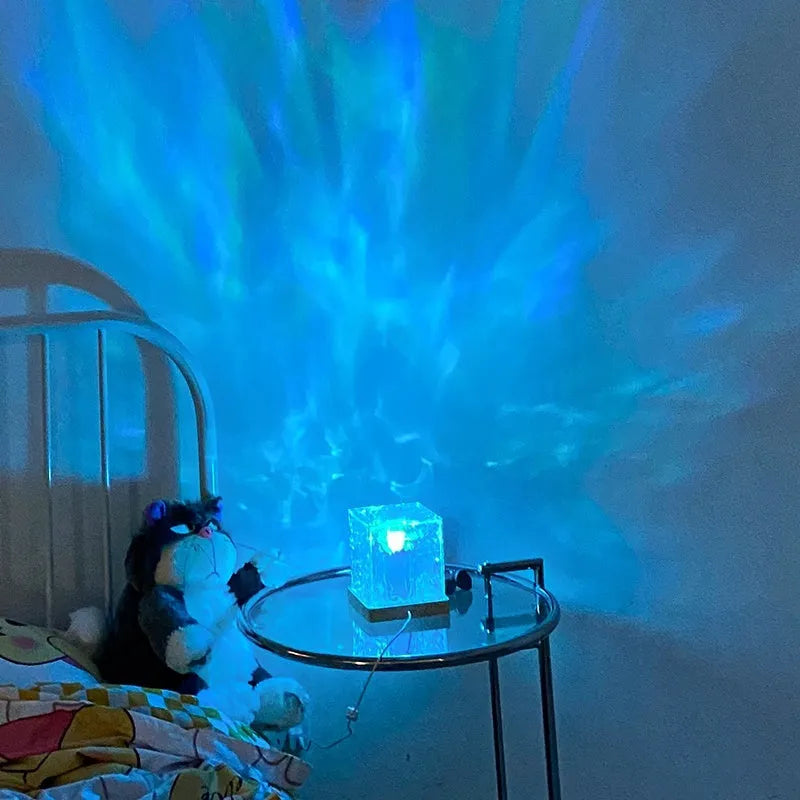 USB-powered crystal table lamp projecting blue water ripple light patterns on a wall