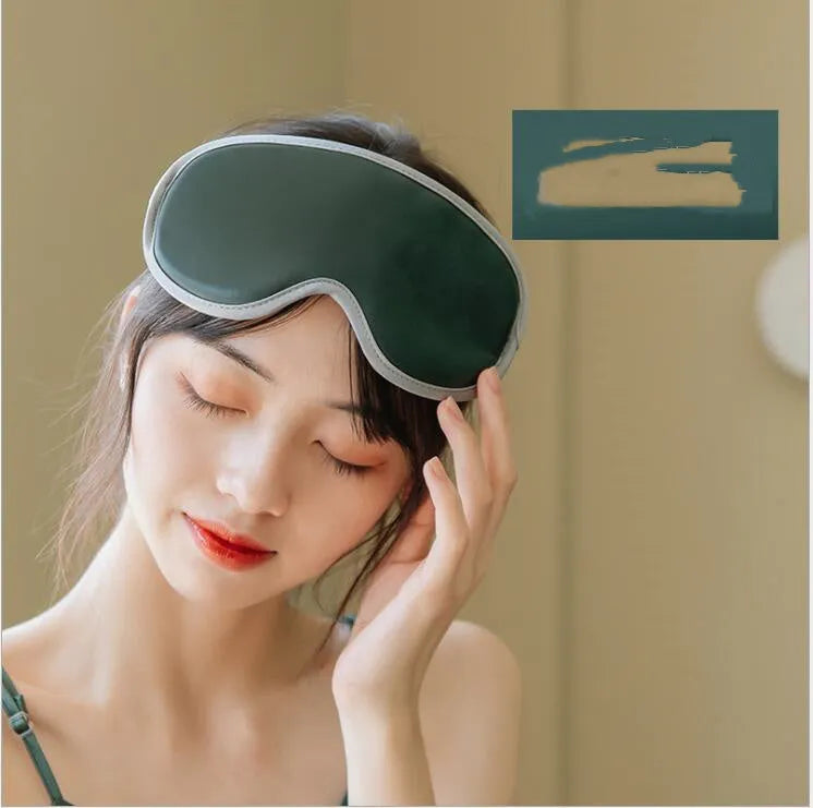 Pink portable eye SPA mask with suede shell on a grey background, showing USB port.