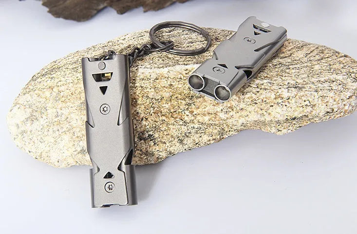 Compact keychain whistle in black and silver with keychain attachment for portable emergency signalling