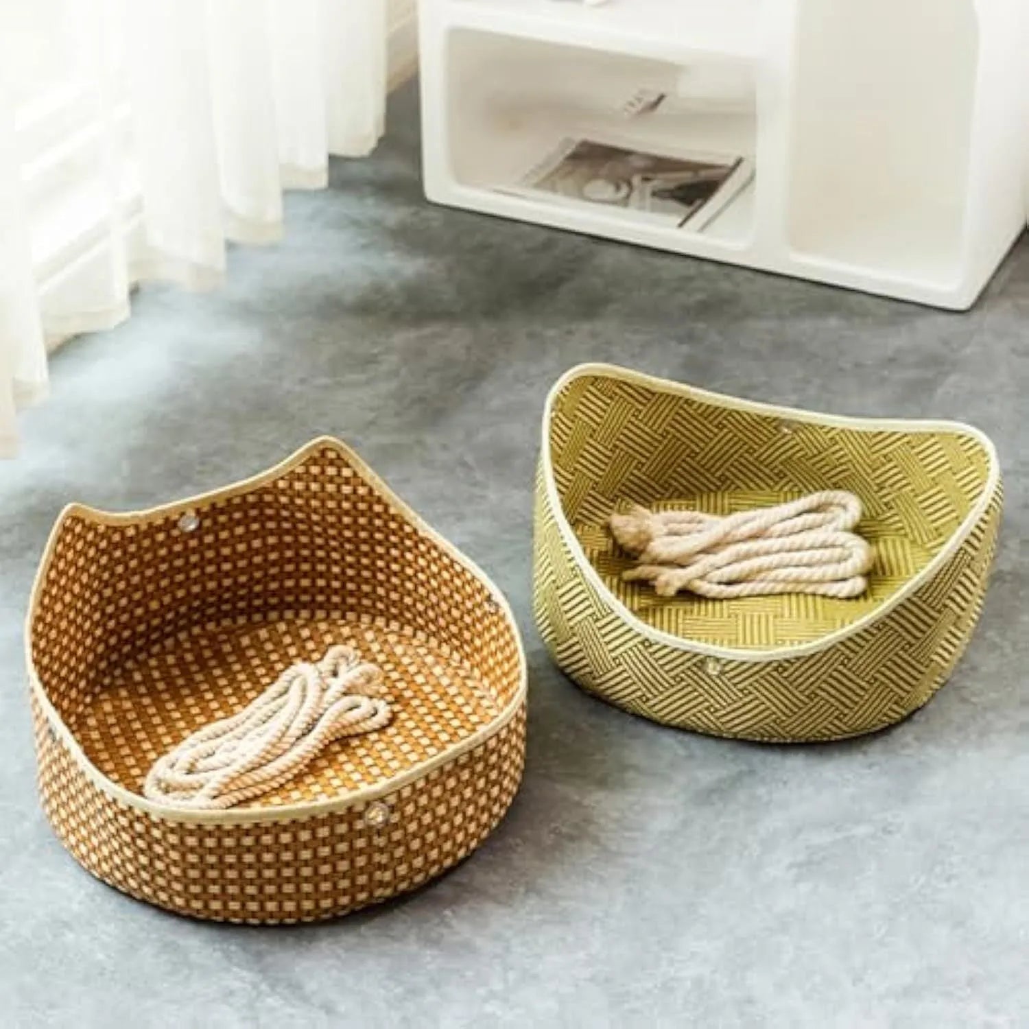 Green rattan cat hammock with metal hooks hanging on a white cage.