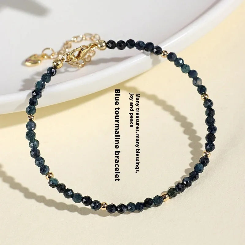 Blue tourmaline bracelet with 3mm beads and metal spacer sections on wrist