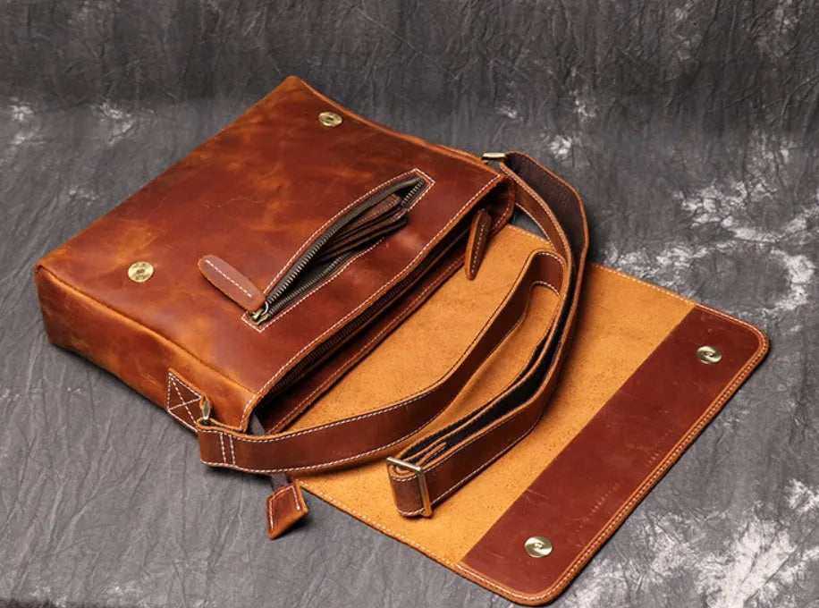 Vintage brown leather men's messenger bag with flap opening and adjustable shoulder strap.
