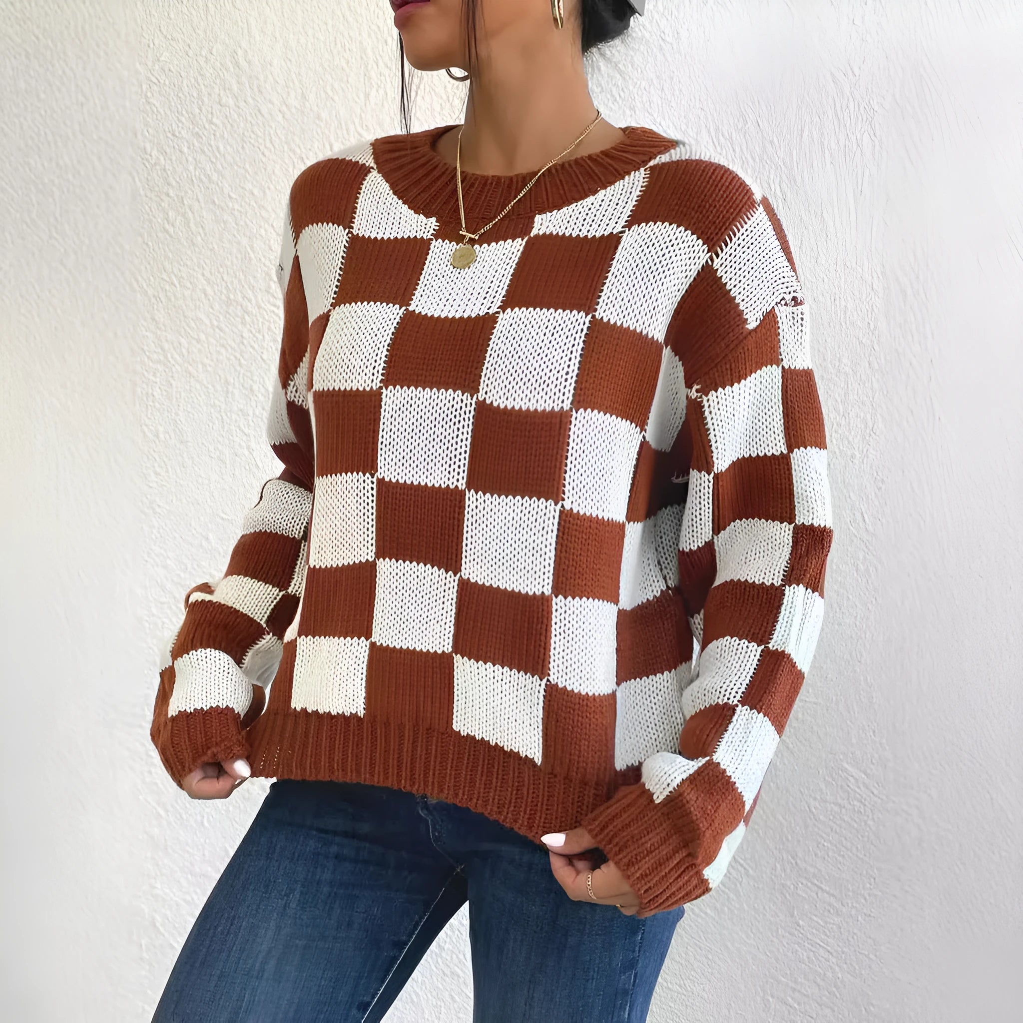 Dark brown loose plaid pullover sweater with a chessboard pattern and long sleeves.