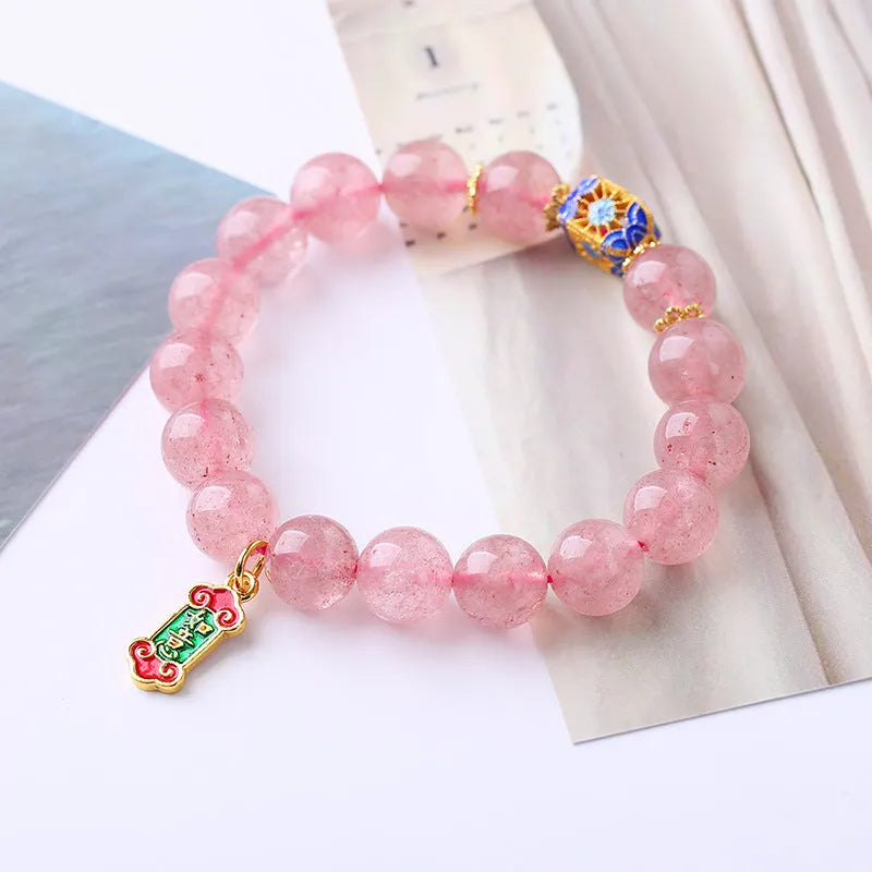 Close-up of hand-woven pink strawberry quartz crystal bracelet with Ruyi motif design