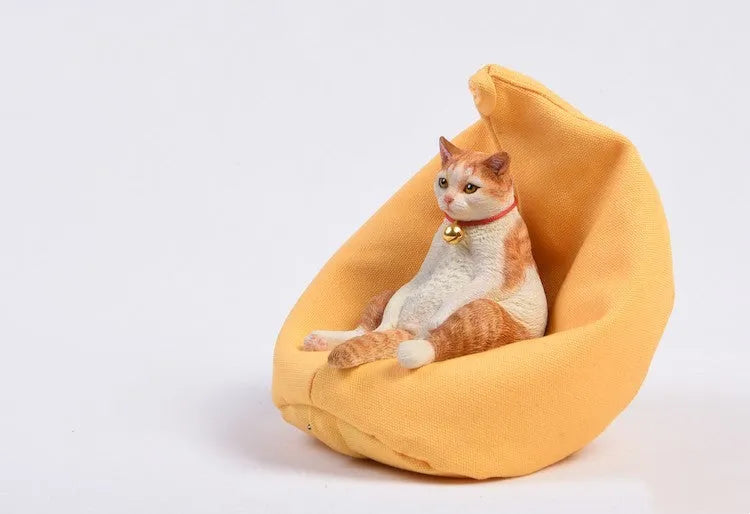 Lazy cat and sofa miniature car dashboard ornament made from resin, approximately 7.5cm high.