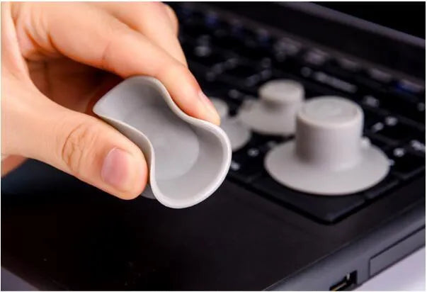Grey plastic laptop cooling pad set showing two large and two small non-slip pads on a desk.