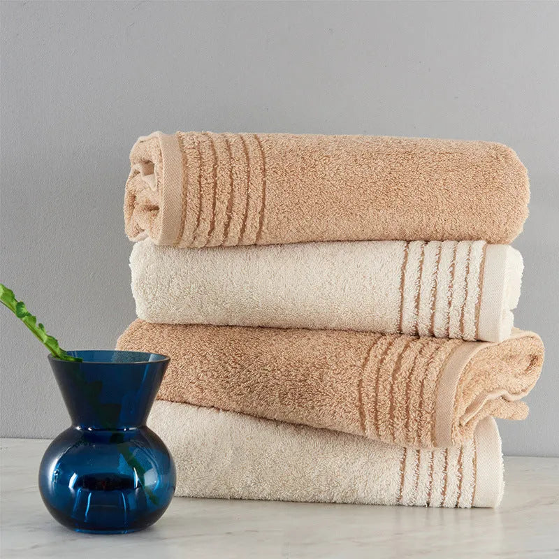 Beige and brown cotton towel set showing face cloth, hand towel and bath towel sizes.