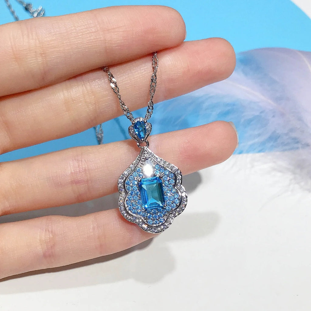 Sea blue geometric copper pendant charm with aquamarine topaz design, shown without a chain.