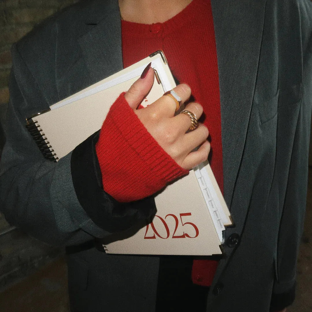 Cherry red A5 daily schedule coil notebook with spiral binding open on desk