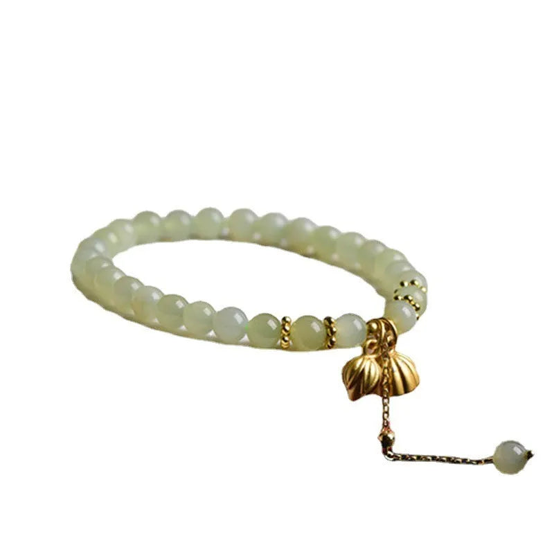 Natural Hetian jade bracelet with a carved Fu character charm on a wrist.