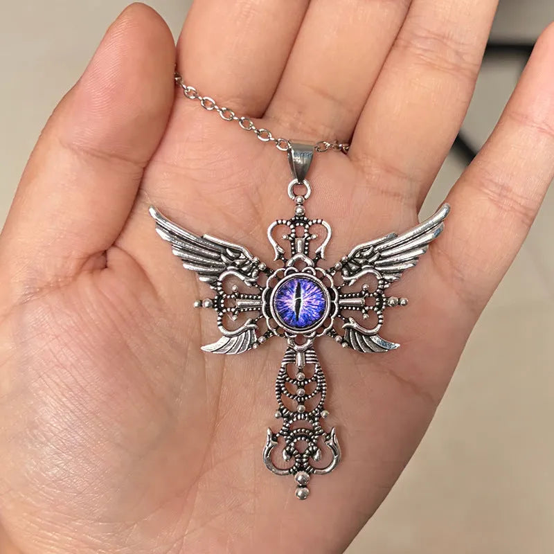 Close-up of a colourful alloy necklace featuring a geometric pendant with devil wings and a cross design.