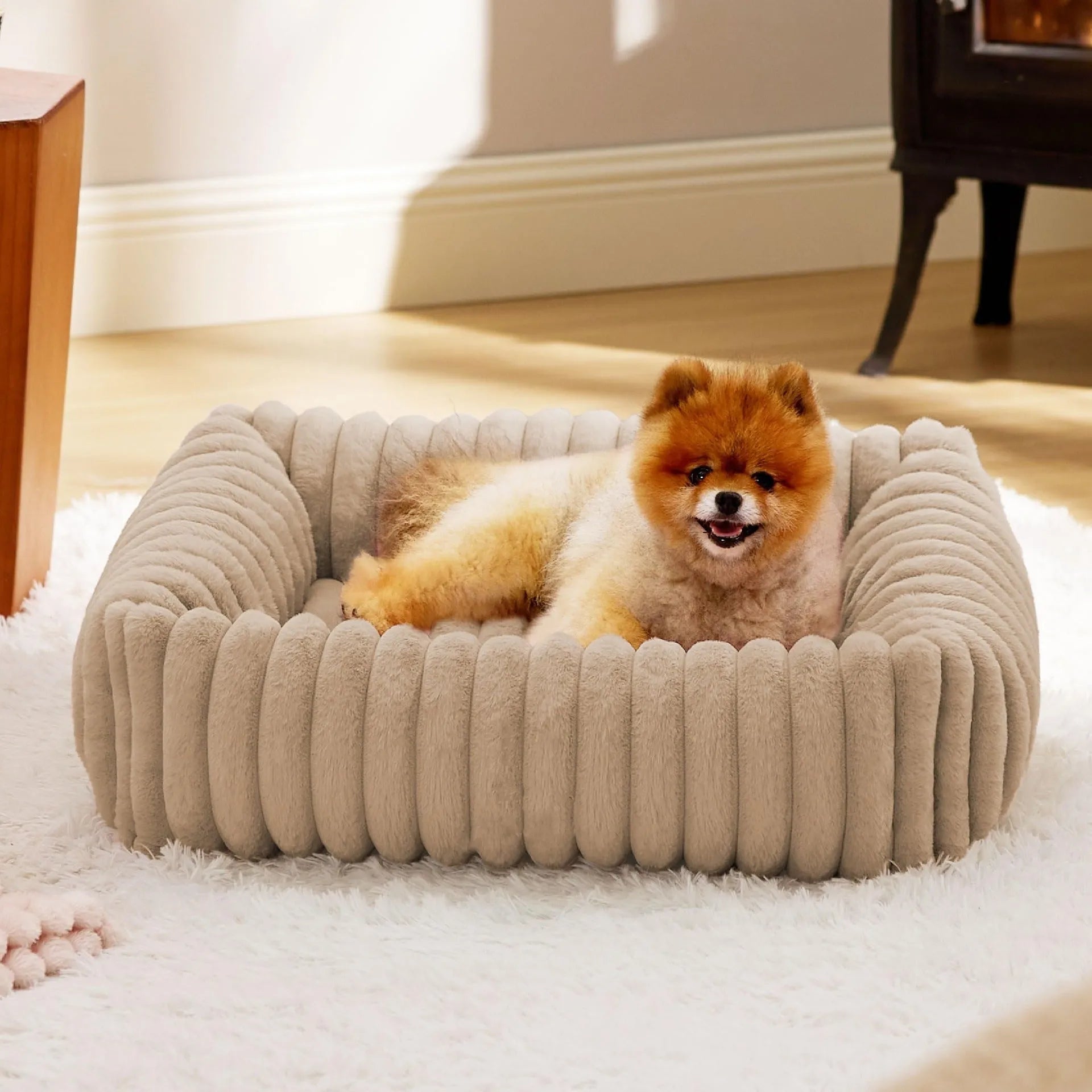 A beige winter-warm cushioned pet bed for cats and dogs on a wooden floor.
