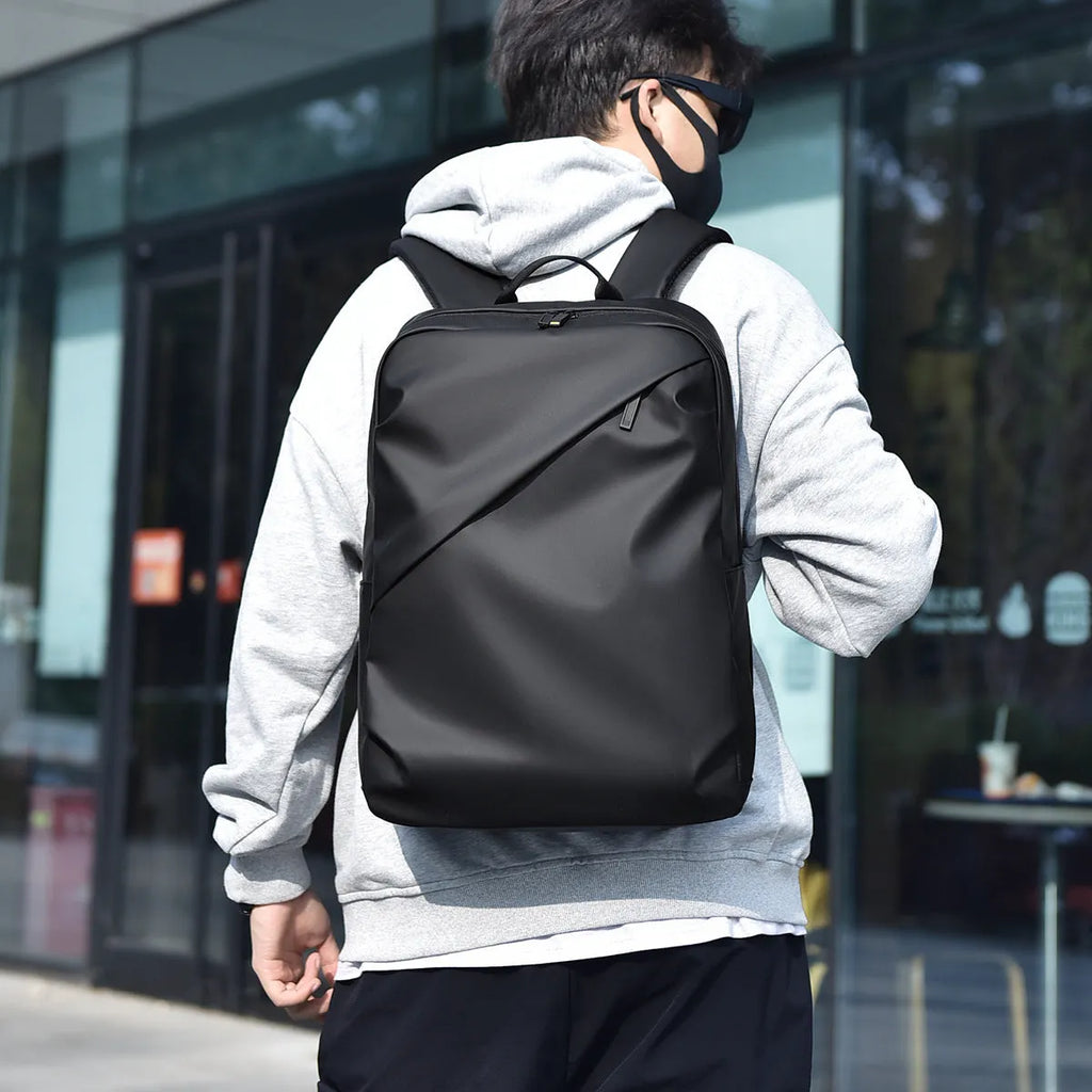 Large black waterproof PU leather backpack for men with prominent stitching, shown next to blue and grey colour options.