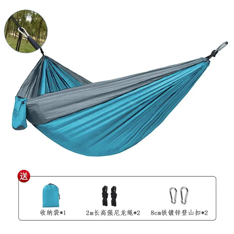 Blue parachute nylon outdoor hammock hung between two trees