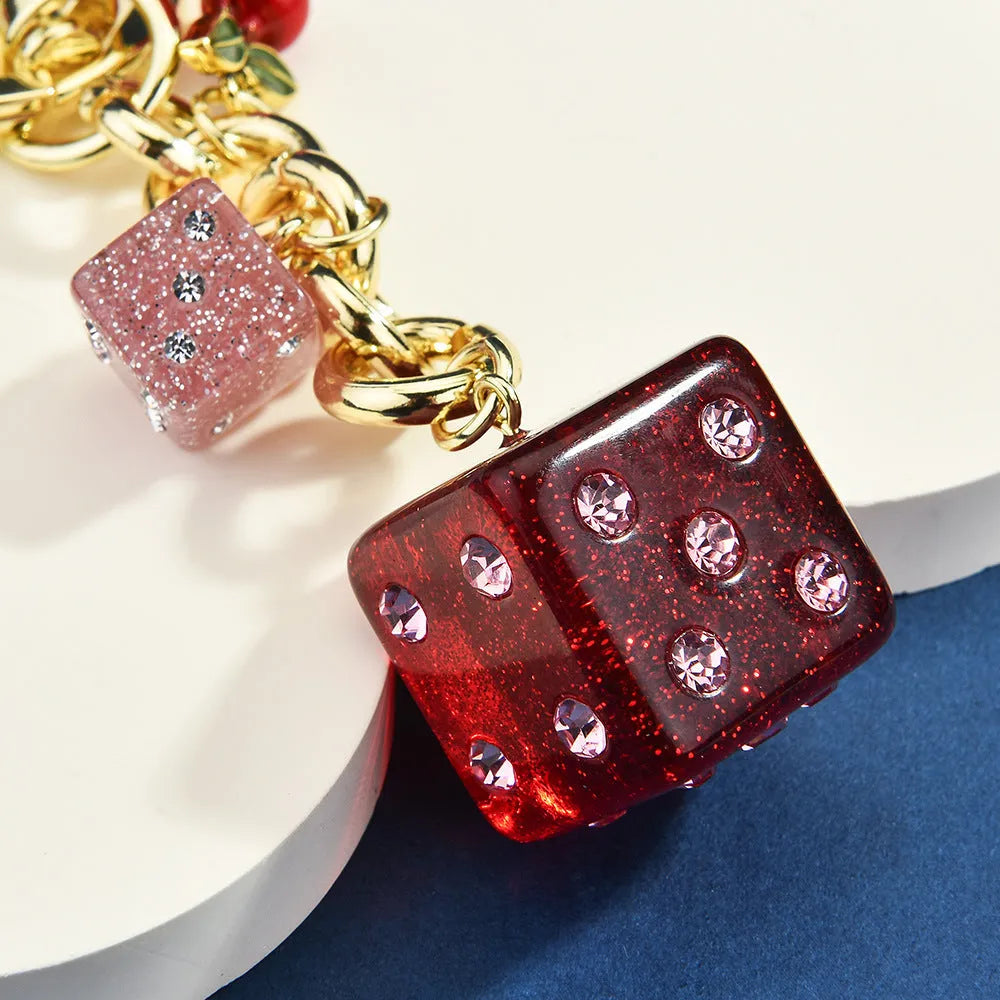 Square metal keychain pendant with a vintage cherry two-tone dice pattern and electroplated finish.