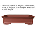 Large rectangular handmade purple clay flowerpot shown in a garden setting.