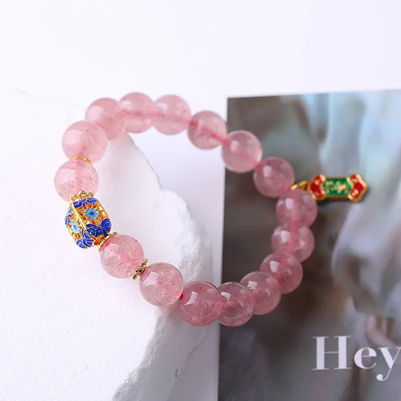 Close-up of hand-woven pink strawberry quartz crystal bracelet with Ruyi motif design