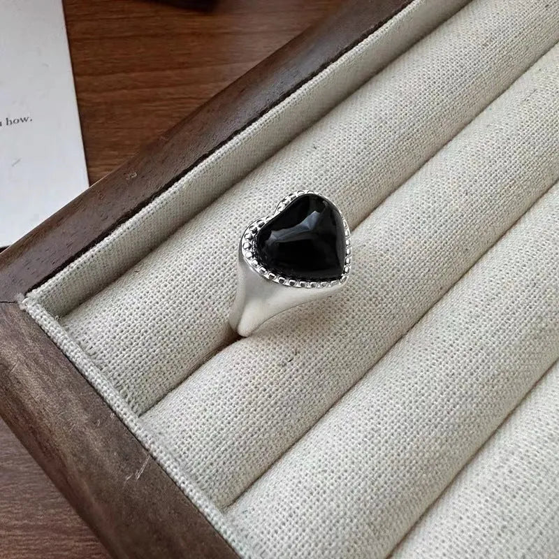 Sterling silver ring with a heart-shaped black agate stone and an adjustable open mouth design.