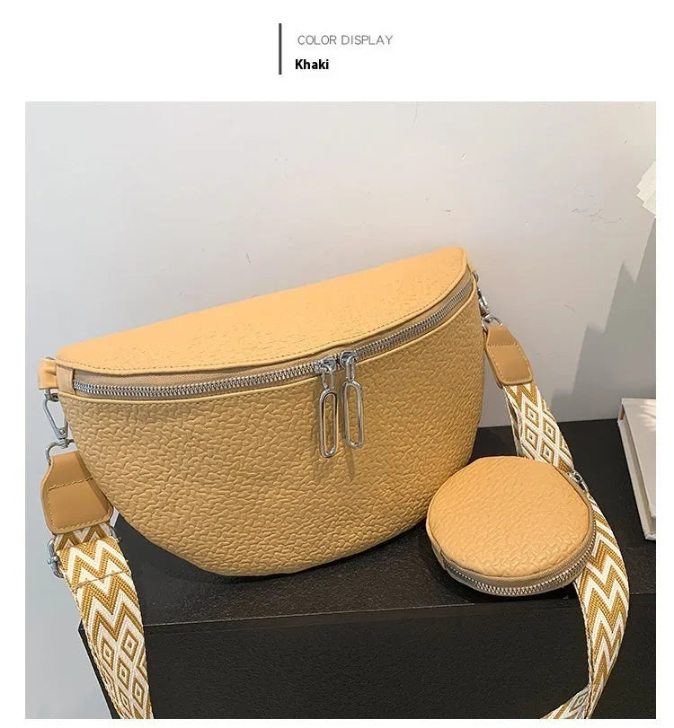 Solid colour women's crossbody bag with saddle lock detail, shown in a horizontal square clamshell shape.