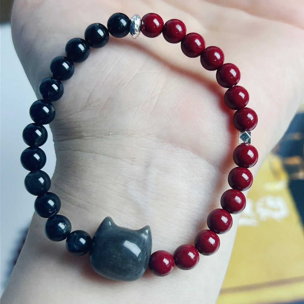 Handcrafted obsidian bracelet with colourful gemstone beads and silver cat charm on wrist