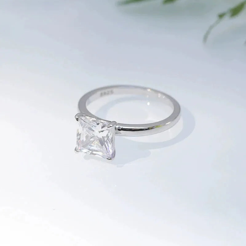 A 925 sterling silver ring with a single round cubic zirconia stone on a geometric band.
