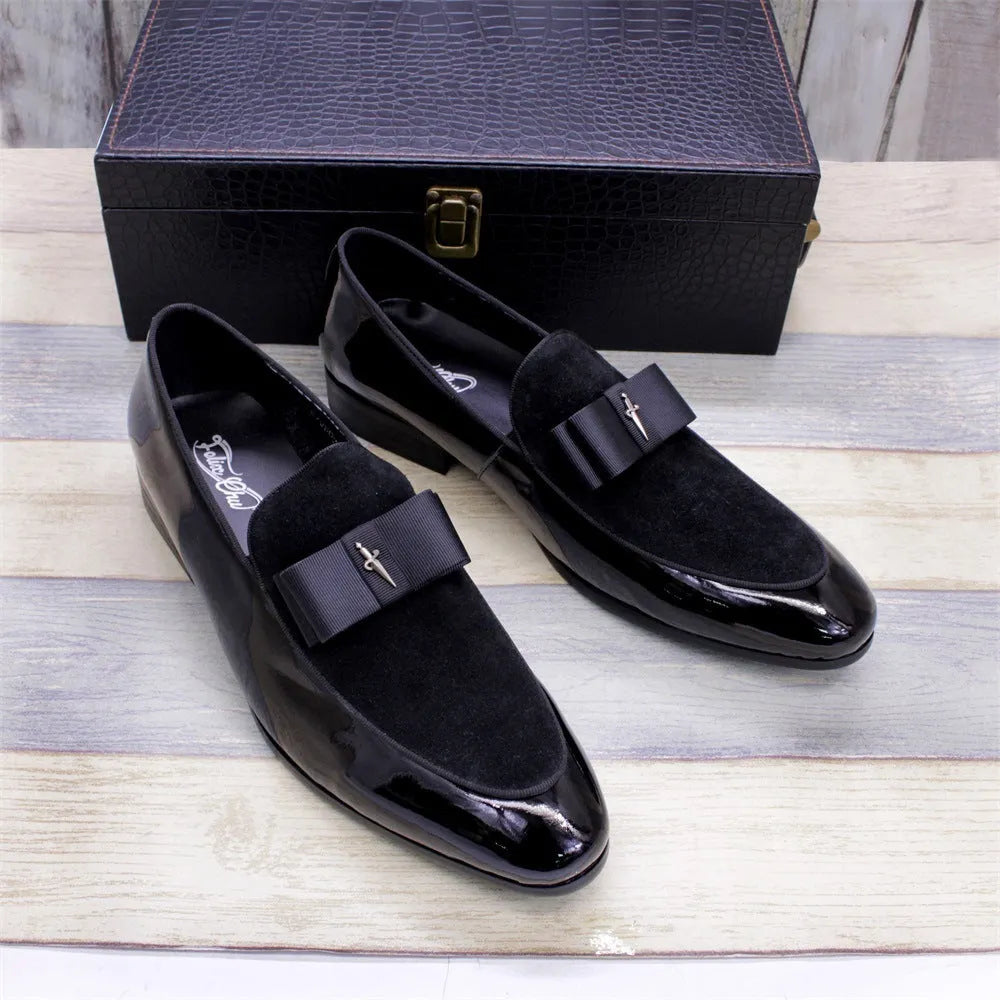 Men's black patent leather low-top dress shoes with a tassel detail on a rubber sole.