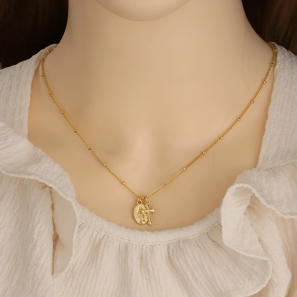 Gold coloured geometric cross necklace with a Virgin Mary ornament pendant for women.