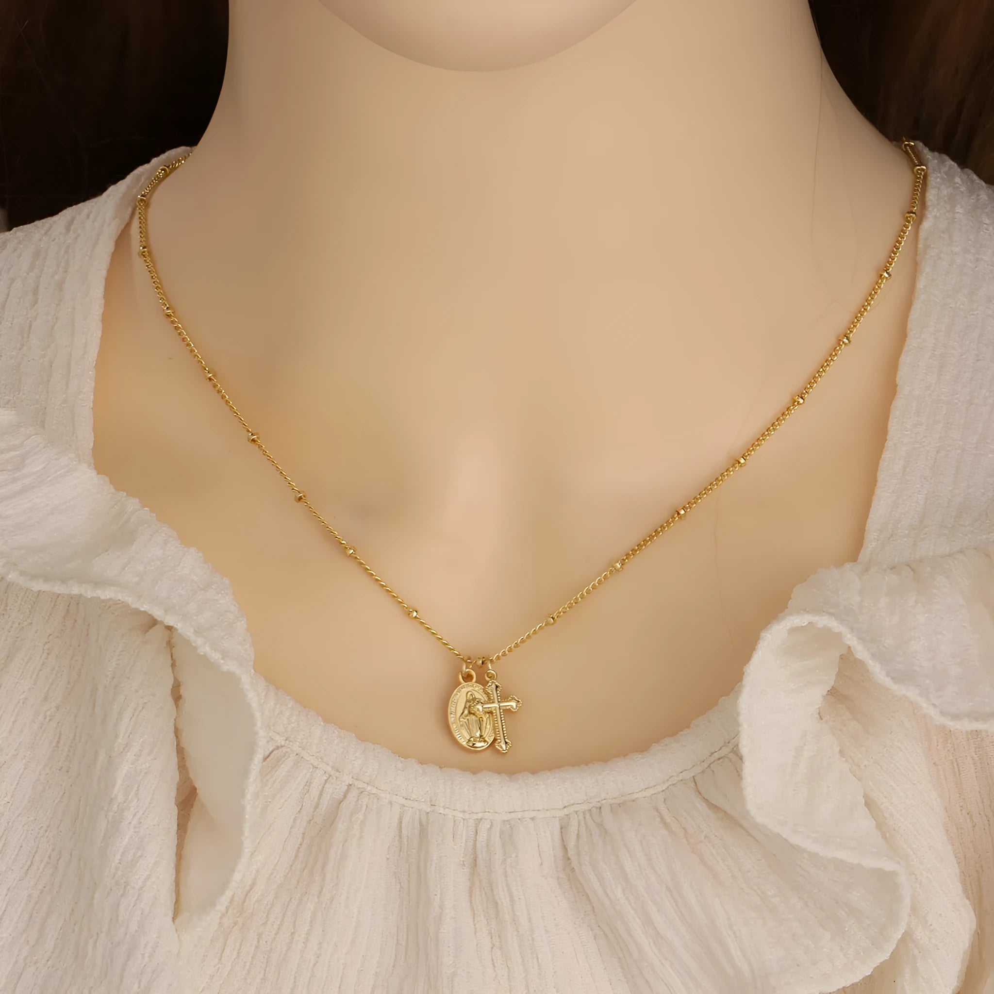 Gold coloured geometric cross necklace with a Virgin Mary ornament pendant for women.