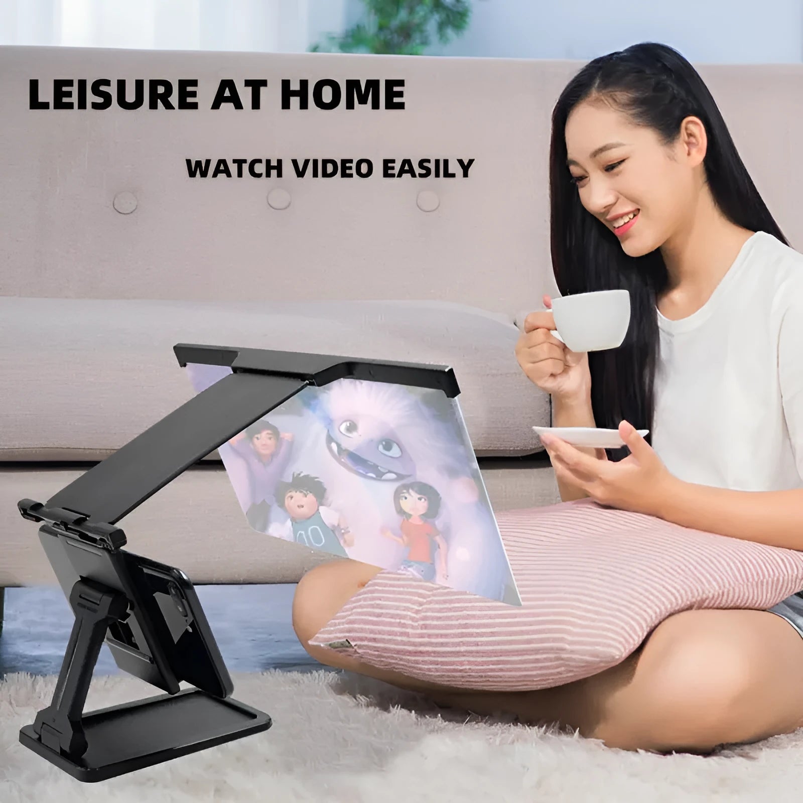 Black folding mobile phone screen amplifier with detachable holder on a desktop.
