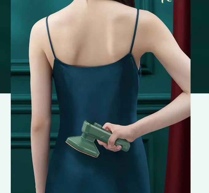 Dark green portable hand-held steam ironing machine with a ceramic panel.