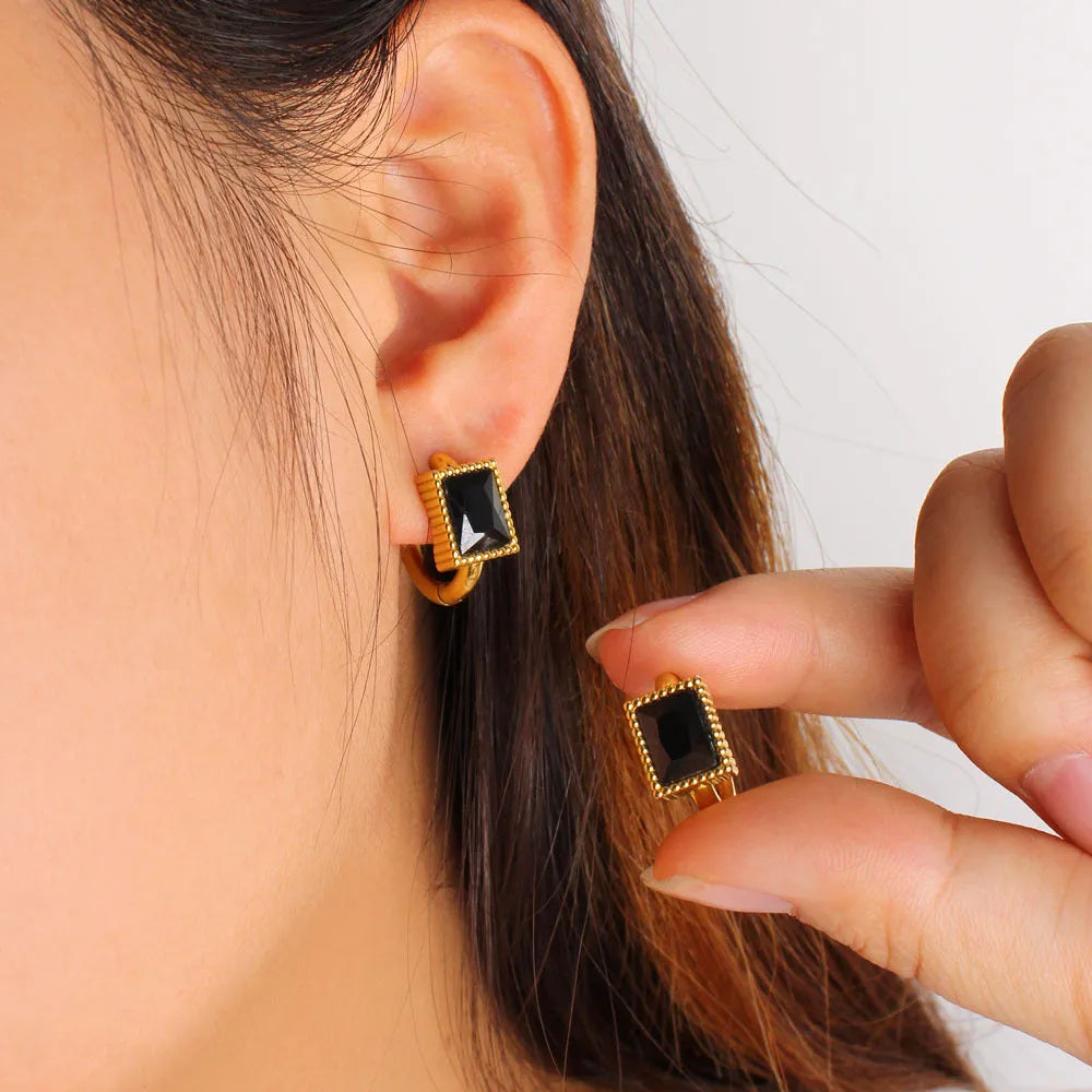 A pair of square geometric zircon stainless steel earrings on a white background.